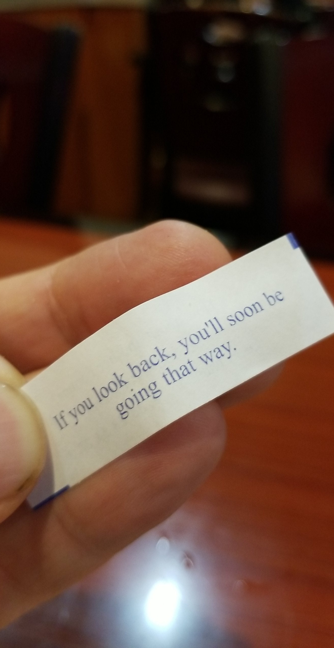 a slip of paper from a fortune cookie bearing the words if you look back, youll soon be going that way
